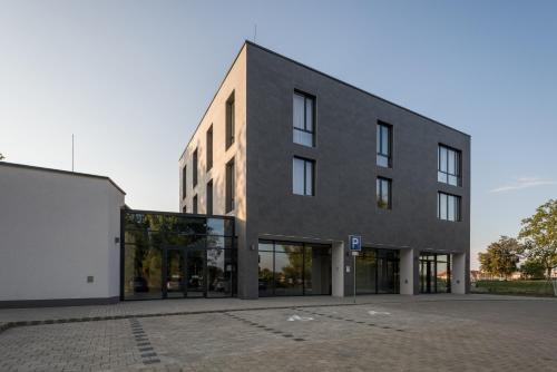 a large black building with glass windows at Várda Sport Hotel in Kisvárda