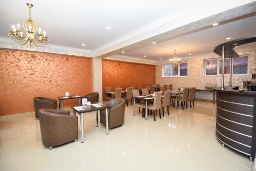 een restaurant met tafels en stoelen en een kroonluchter bij Laguna Hotel in Vanadzor