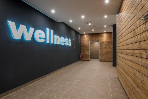 a hallway with a wall with the wellness sign on it at Várda Sport Hotel in Kisvárda