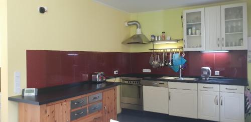 a kitchen with white cabinets and a black counter top at Traumhaftes Apartment in Mönchengladbach Ohler in Mönchengladbach