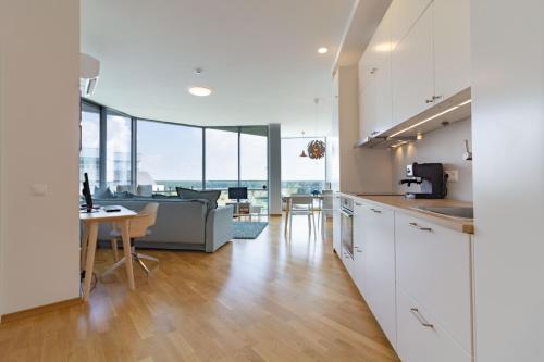 a kitchen and living room with a couch and a table at Elija Swan-Toy Apartments in Šventoji