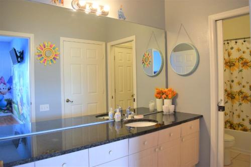 uma casa de banho com um lavatório e um espelho em 3 Bedroom Resort Style Condo, 3 Miles to Disney! em Kissimmee