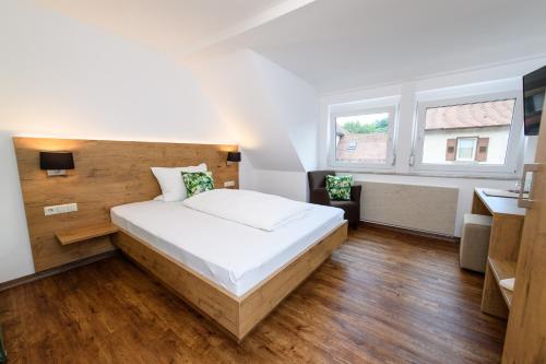 a bedroom with a large white bed and a desk at Zum Scheffelhof in Maulbronn