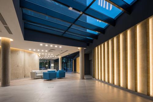 a view of the lobby of a building with blue chairs at Várda Sport Hotel in Kisvárda
