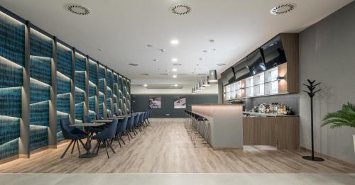 a barbershop with blue chairs and a counter at Várda Sport Hotel in Kisvárda