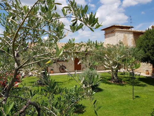a garden with a building in the background at Agriturismo Arcobaleno della Torretta in Giano dellʼUmbria