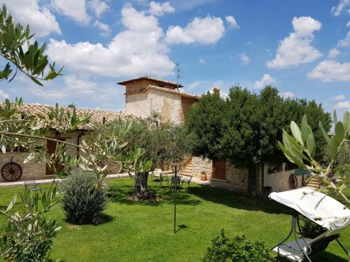 a garden with a house and some trees at Agriturismo Arcobaleno della Torretta in Giano dellʼUmbria
