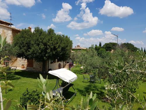 a garden with an umbrella on the grass at Agriturismo Arcobaleno della Torretta in Giano dellʼUmbria