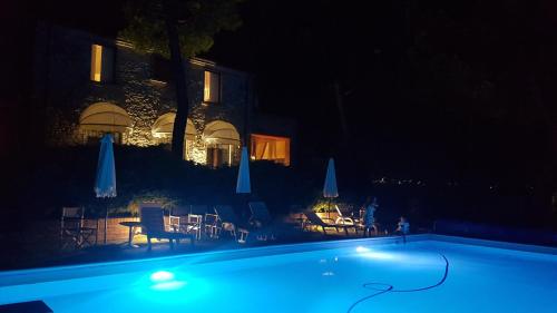 a swimming pool at night with chairs and umbrellas at Villa Vittoria in Citta' Sant'Angelo