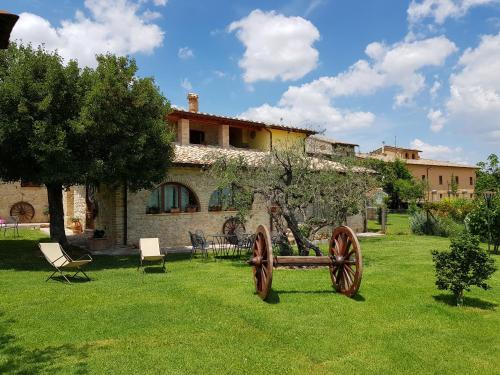 a garden with a bench in front of a house at Agriturismo Arcobaleno della Torretta in Giano dellʼUmbria