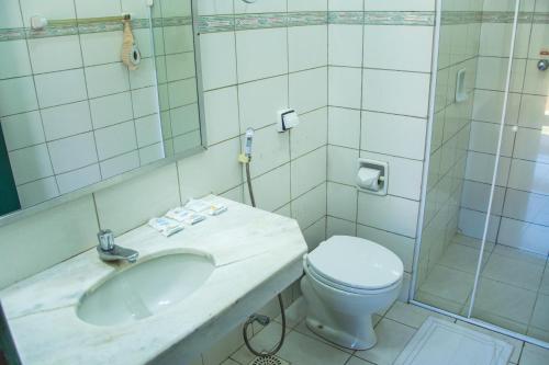 e bagno con servizi igienici, lavandino e doccia. di Candeias Hotel Gold Fish a Corumbá