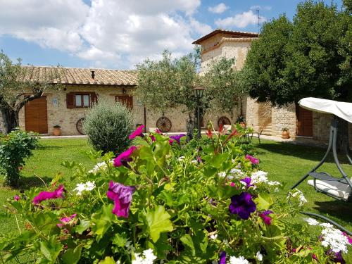 a garden with flowers in front of a building at Agriturismo Arcobaleno della Torretta in Giano dellʼUmbria