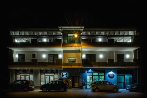 two cars parked in front of a building at night at Hotel New Bari in Bitritto