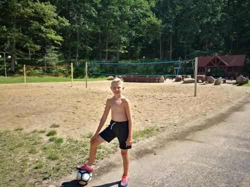 a young boy is standing with a soccer ball at Pokoje hotelowe Nad jeziorem Jelen in Bytów