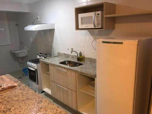 a small kitchen with a sink and a microwave at Serra Madre in Rio Quente