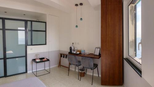 a room with a desk and chairs and a window at Agave Room Rental in Riomaggiore