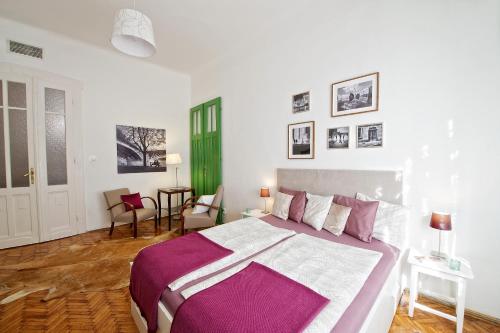 a bedroom with a large bed with purple and white sheets at Green Door Family Apartment in Budapest