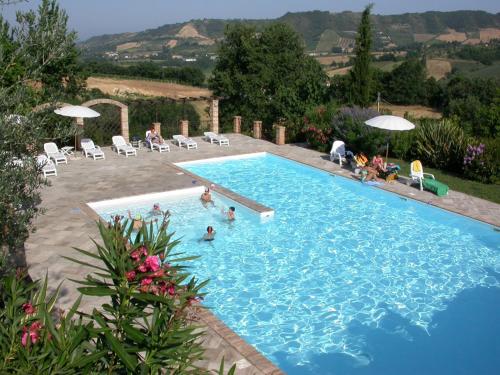 a large blue swimming pool with people in it at Agriturismo La Campana in Montefiore dellʼAso