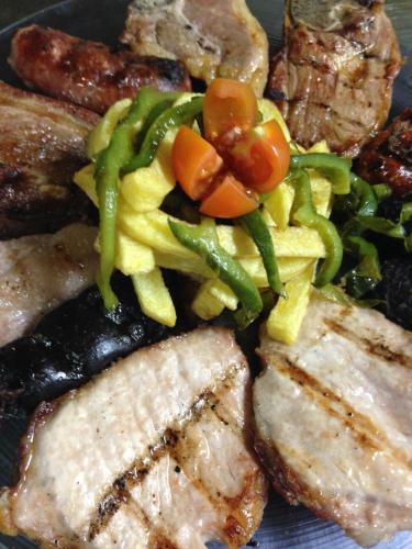 a plate of food with meat and vegetables on it at Hostal Los Maños in Albentosa