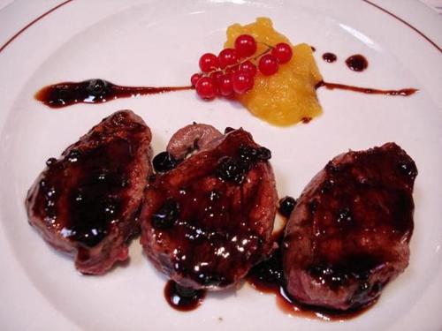 a plate of food with meat and fruit on it at Hostal Los Maños in Albentosa