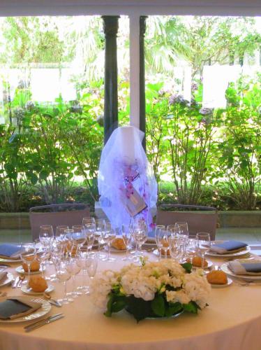 a table with glasses and a vase with flowers on it at Hotel Gudamendi in Donostia-San Sebastián