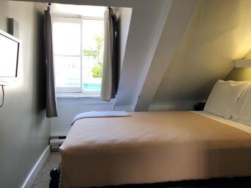 a bedroom with a large bed and a window at Auberge St-Louis in Quebec City
