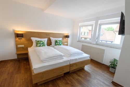 a bedroom with a large bed with a wooden headboard at Zum Scheffelhof in Maulbronn