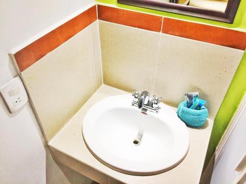 baño con lavabo blanco en una habitación en Hotel Plazha, en Tuxtla Gutiérrez