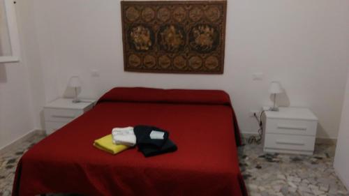 sypialnia z czerwonym łóżkiem i 2 szafkami nocnymi w obiekcie A Due Passi Da Cisanello Casa Vacanze w Pizie