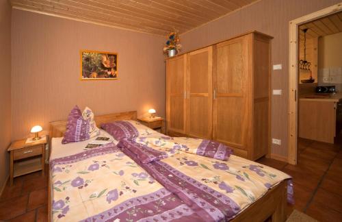 WarnitzにあるFerienhaus Buchholzのベッドルーム1室(ベッド1台付)、木製キャビネットが備わります。