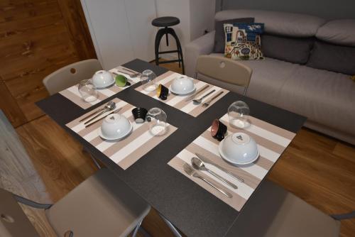 a table in a living room with plates and utensils at La dimora del barone in Salerno