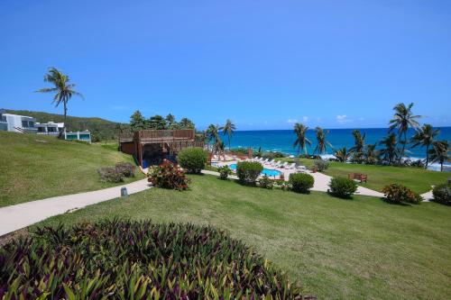 a view of a resort with a pool and the ocean at Hotel El Guajataca in Quebradillas