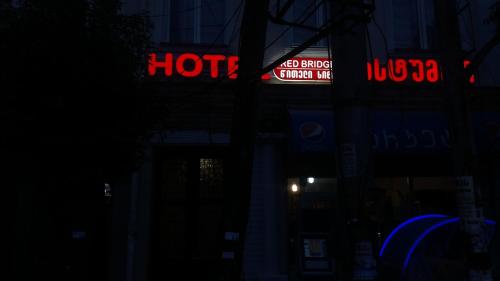 a building with neon signs on it at night at Hotel Red Bridge in Kutaisi