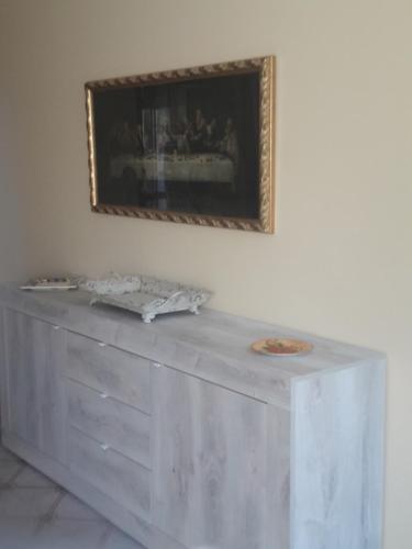 a white table with a picture on the wall at I Fiori Di Lucrezia in Monteroni di Lecce