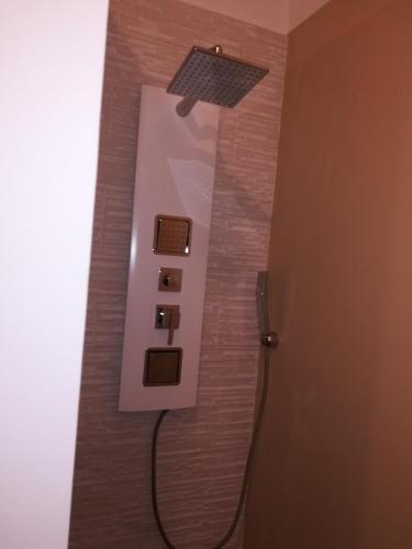 a bathroom with a shower with a light on the wall at B&B Suites Via del Mare in Presicce