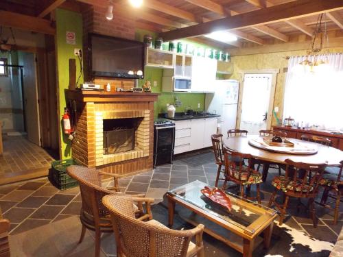a kitchen and dining room with a table and a fireplace at Sobrado Estilo Alemão in Canela