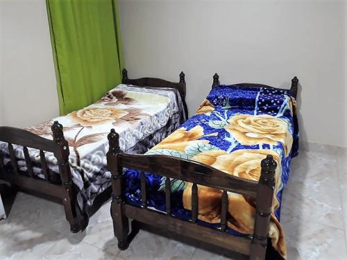 dos camas sentadas una al lado de la otra en una habitación en Aparthostel Cataratas del Iguazu en Puerto Iguazú