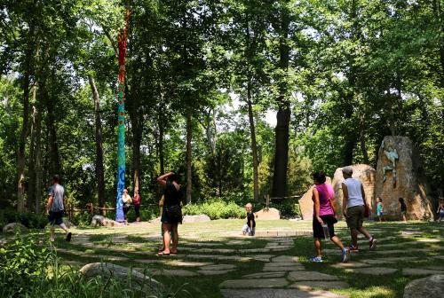 a group of people walking in a park at Three Village Inn in Stony Brook