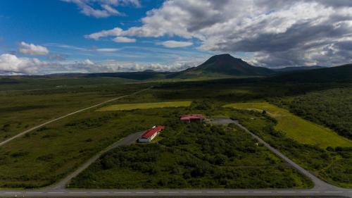a train on a road in a field with a mountain at Dettifoss Guesthouse in Skinnastadur