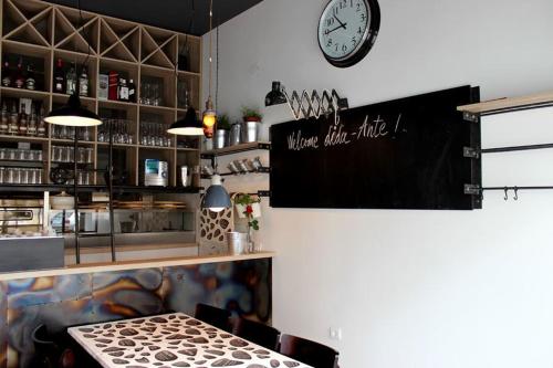 a bar with a clock on the wall and a table at Car Royal Apartments and Rooms in Novi Sad