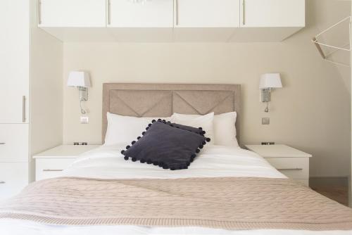 a bed with a black pillow on top of it at The Soho Loft - Elegant & Modern 1BDR in London