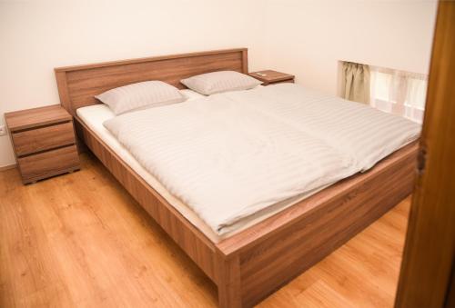 sypialnia z dużym łóżkiem z białą pościelą w obiekcie Centrum Apartman w mieście Cegléd