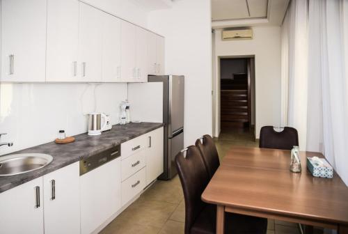 cocina con mesa de madera y comedor en Centrum Apartman, en Cegléd