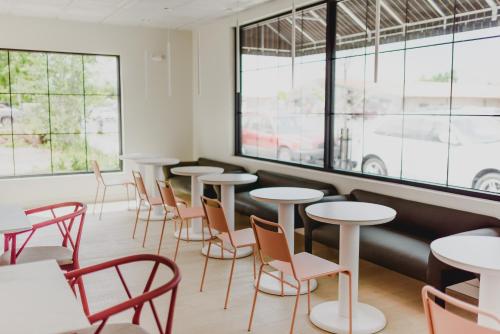 a row of tables and chairs in a room with windows at RSVP Hotel in Bozeman