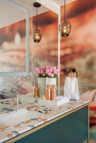a counter with a sink with flowers and lights at RSVP Hotel in Bozeman
