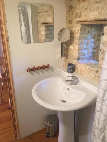 a bathroom with a sink and a mirror at Les Trois Piliers in Saint-Clair