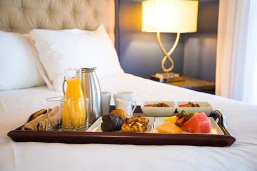 a tray of food on a bed with drinks and fruit at Carter Estate Winery and Resort in Temecula