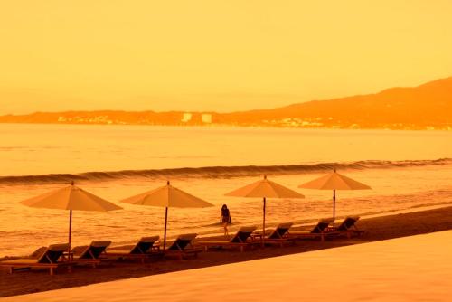 a group of chairs and umbrellas on a beach at Krystal Grand Nuevo Vallarta in Nuevo Vallarta 