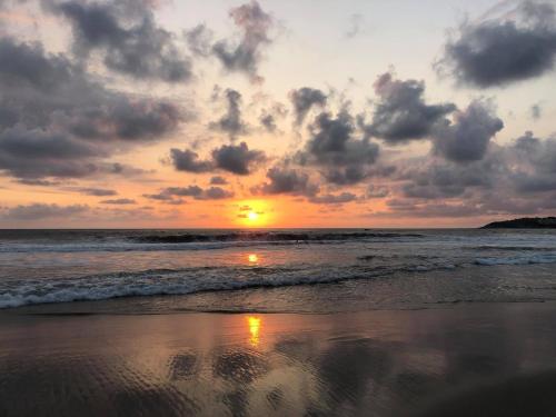 a sunset on a beach with the ocean at Bungalows Zicatela in Puerto Escondido
