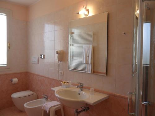 a bathroom with a sink and a toilet and a mirror at Cà Rocca Relais in Monselice